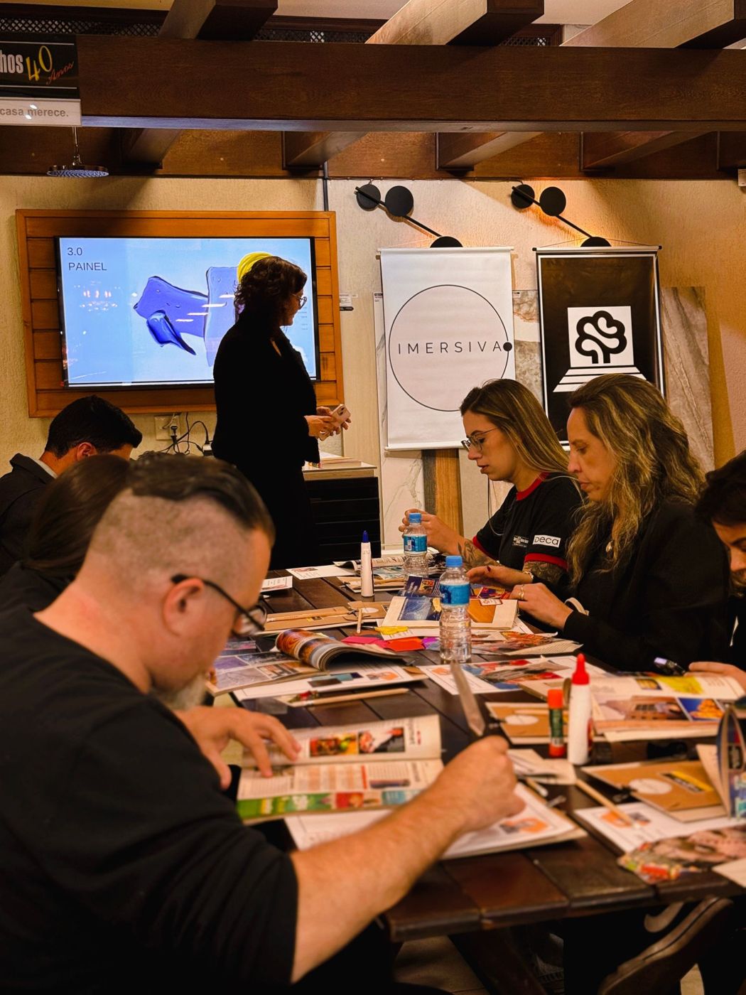 Participantes montando painéis com recortes de revista